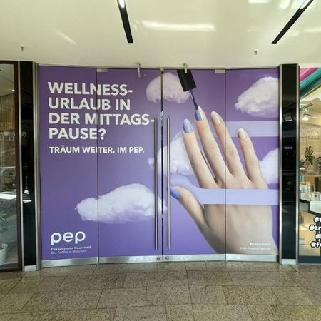 Anzeige für Wellness in der Mittagspause mit Händen in den Wolken, angebracht an der Tür eines Einkaufszentrums.