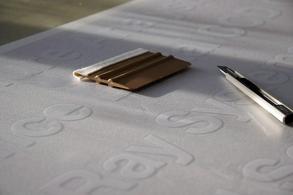 Notizblock mit Stift auf einer geprägten Oberfläche bei sanfter Beleuchtung.