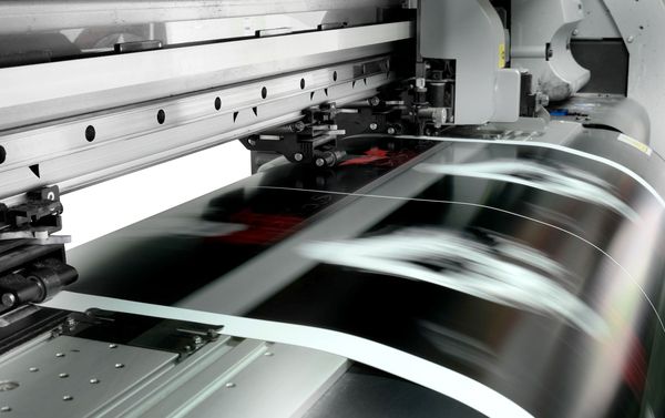 Hochgeschwindigkeits-Offsetdruckmaschine in Betrieb mit unscharfer Papierbewegung.