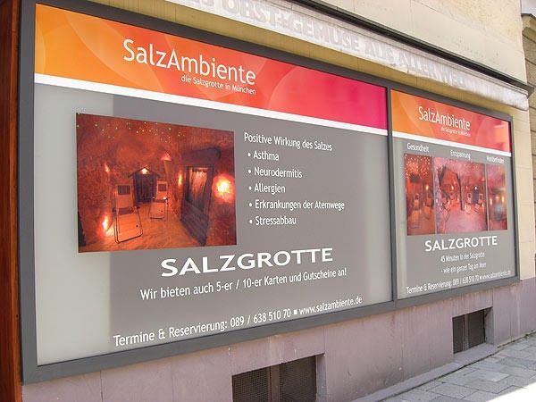 Schaufenster von 'SalzAmbiente Salzgrotte' mit Werbeplakaten, auf denen Dienstleistungen und Kontaktinformationen vorgestellt werden.